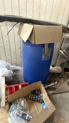 une caisse à outils posée par terre à côté d'un fût bleu