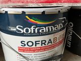 a bucket of paint sitting on the ground next to a bucket of paint