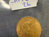 a close up of a gold coin with a note attached to it