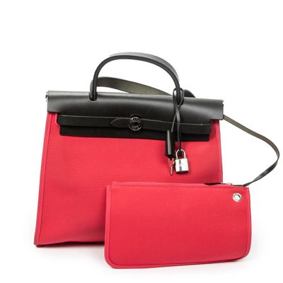 two pieces of red and black purses on a white surface