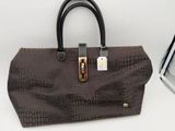 the brown purse is next to a box with a tag on it