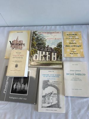 several books are sitting on a bed with a white sheet