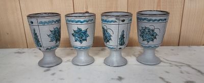 four blue and white vases sitting on top of a marble counter top