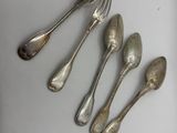 five silver spoons and two silver spoons on a white plate