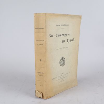 un vieux livre posé sur une table à côté d'un mur blanc