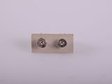 a close up of a pair of silver earrings on a white surface
