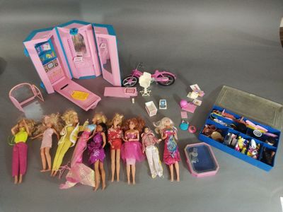 tout un tas de poupées Barbie posées sur une table