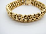 gros plan d'un bracelet en or sur une surface blanche