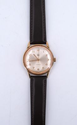 une image d'un gros plan d'une montre-bracelet sur une surface blanche