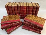 six livres rouges empilés les uns sur les autres sur une surface blanche