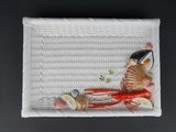 un panier blanc posé sur une table, contenant de la nourriture