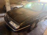 a black car parked in a garage next to other cars