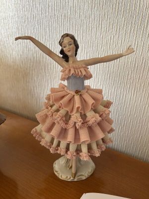 a figurine of a woman in a dress on a table