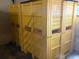 many yellow crates stacked up in a garage