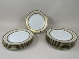six white and gold plates with gold trims on them