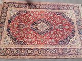 a close up of a rug on a table with a chair in the background