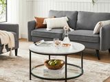 un salon avec un canapé gris et une table basse blanche