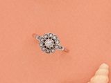 une image représentant une bague en diamant posée sur un coquillage