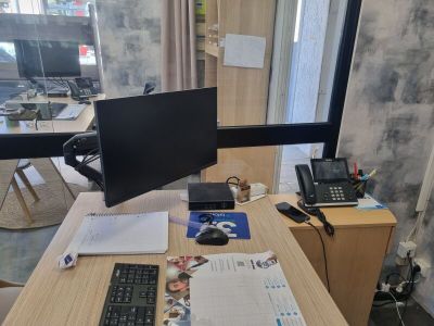 un bureau sur lequel se trouvent un écran d'ordinateur, un clavier, une souris et d'autres objets