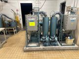 une photo montrant un ensemble de compresseurs d'air industriels dans une pièce
