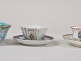 three cups and saucers are lined up on a white surface