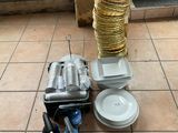 une pile d'assiettes et de casseroles posée par terre, à côté d'une pile d'assiettes