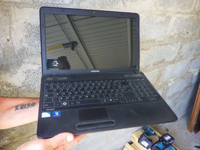 a person holding a laptop computer in their hand
