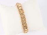 a close up of a gold bracelet on a white pillow
