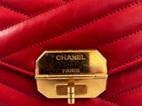 a close up of a red purse with a gold clasp