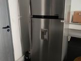 a silver refrigerator next to a white door in a room