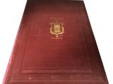 an old red book with a gold emblem on it