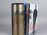 two books in a blue box with a picture of a man in a suit and tie