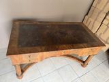une vieille table en bois posée sur un sol carrelé