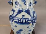 a blue and white vase on a stand on a table