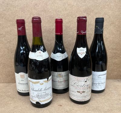 six bouteilles de vin rouge sont alignées sur une table