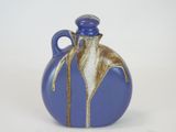 a blue and brown vase with a handle on a white background