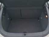 the back of a white car with its trunk open in a parking lot