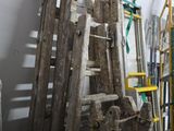 un tas de vieilles échelles en bois près d'un mur blanc