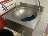 un lavabo en acier inoxydable et une poubelle dans des toilettes publiques