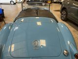 a blue car parked in a showroom with other cars in the background
