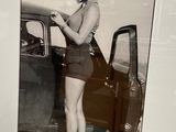 une photo en noir et blanc d'une femme adossée à une voiture