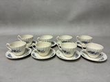 six cups and saucers with blue flowers on them on a table