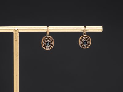 a pair of gold earrings with blue topaz and diamonds