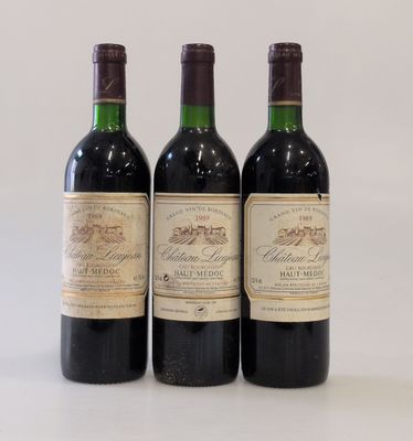 trois bouteilles de vin sont alignées sur une surface blanche