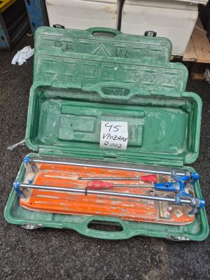 une mallette verte posée par terre, contenant des outils