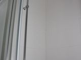 a shower with a glass door in a white bathroom