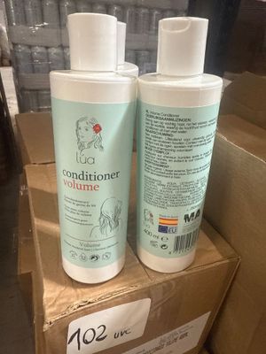 deux flacons d'après-shampoing posés sur une boîte en carton