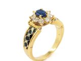 a close up of a gold ring with a sapphire and diamonds