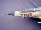 a model of a fighter jet sitting on a blue surface