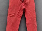 un pantalon rouge suspendu à une corde à linge